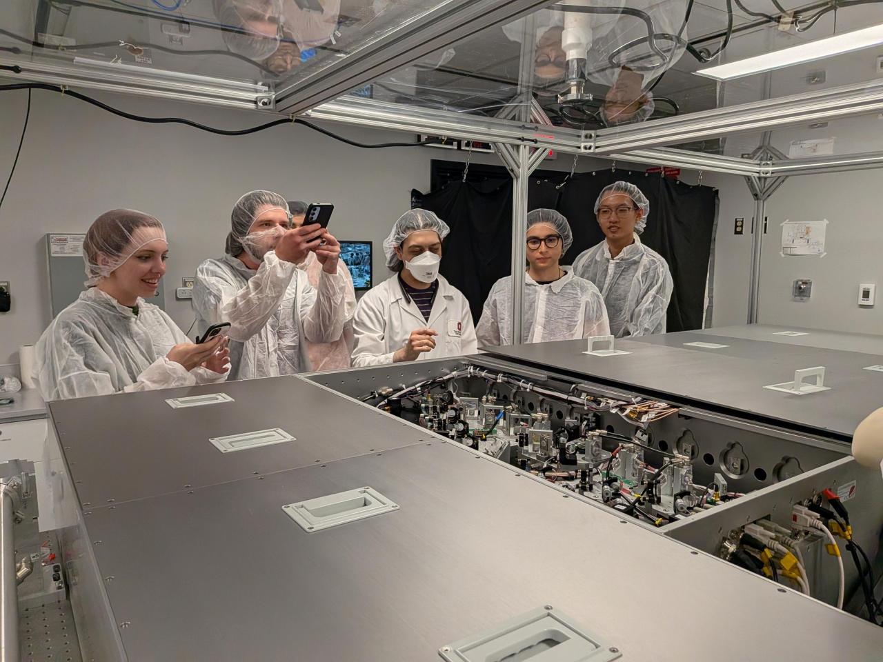 Scientists describe a piece of equipment in the NeXUS lab to undergraduate students