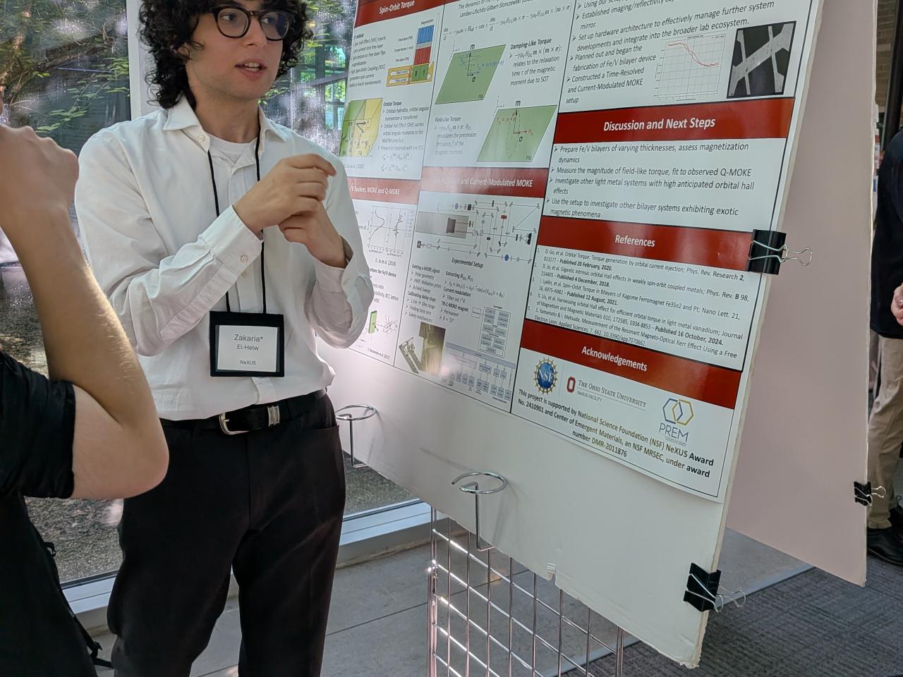 Zakaria El-Helw presenting his research poster to a listener