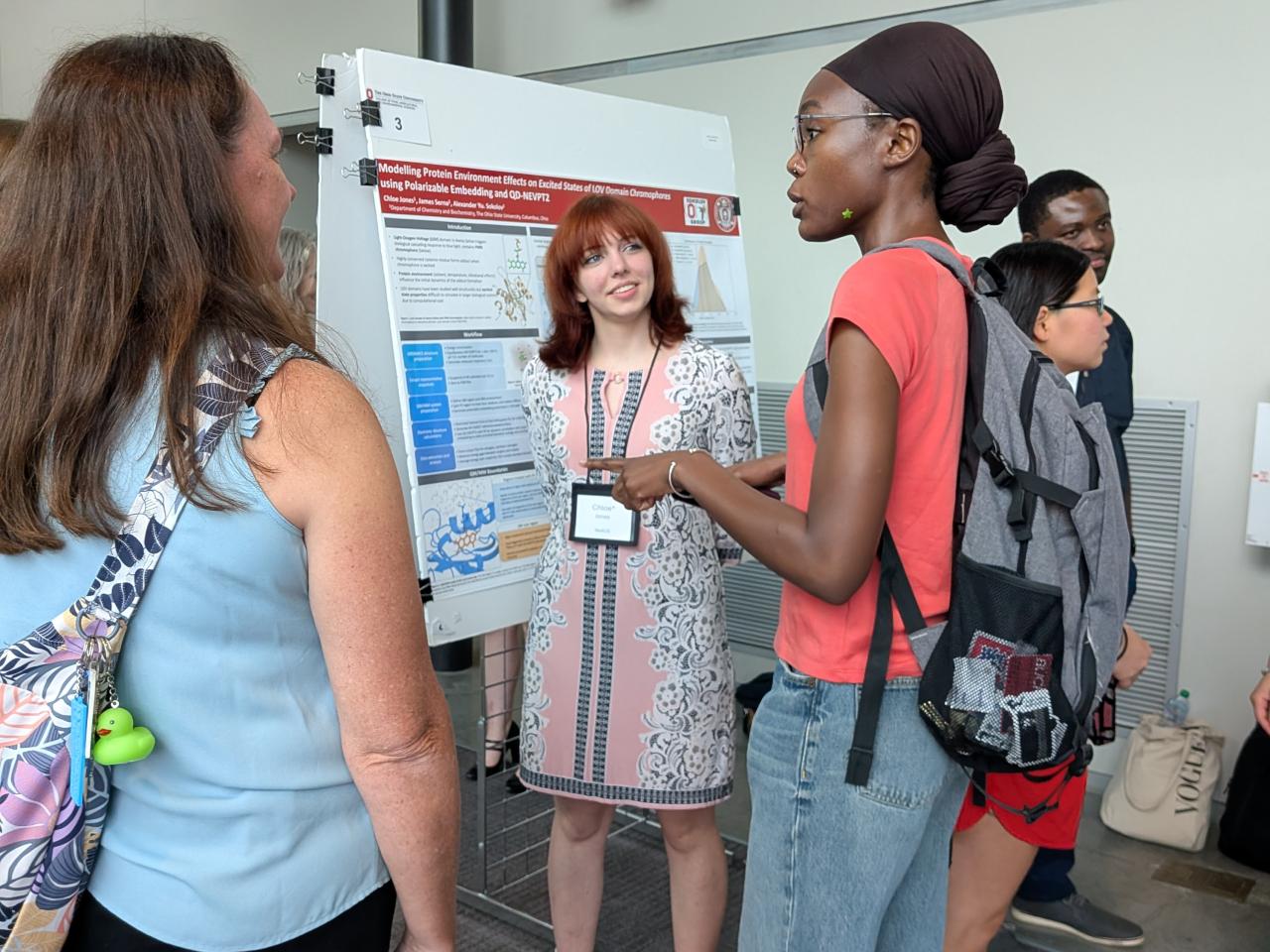 Chloe Jones presenting her research poster with listeners