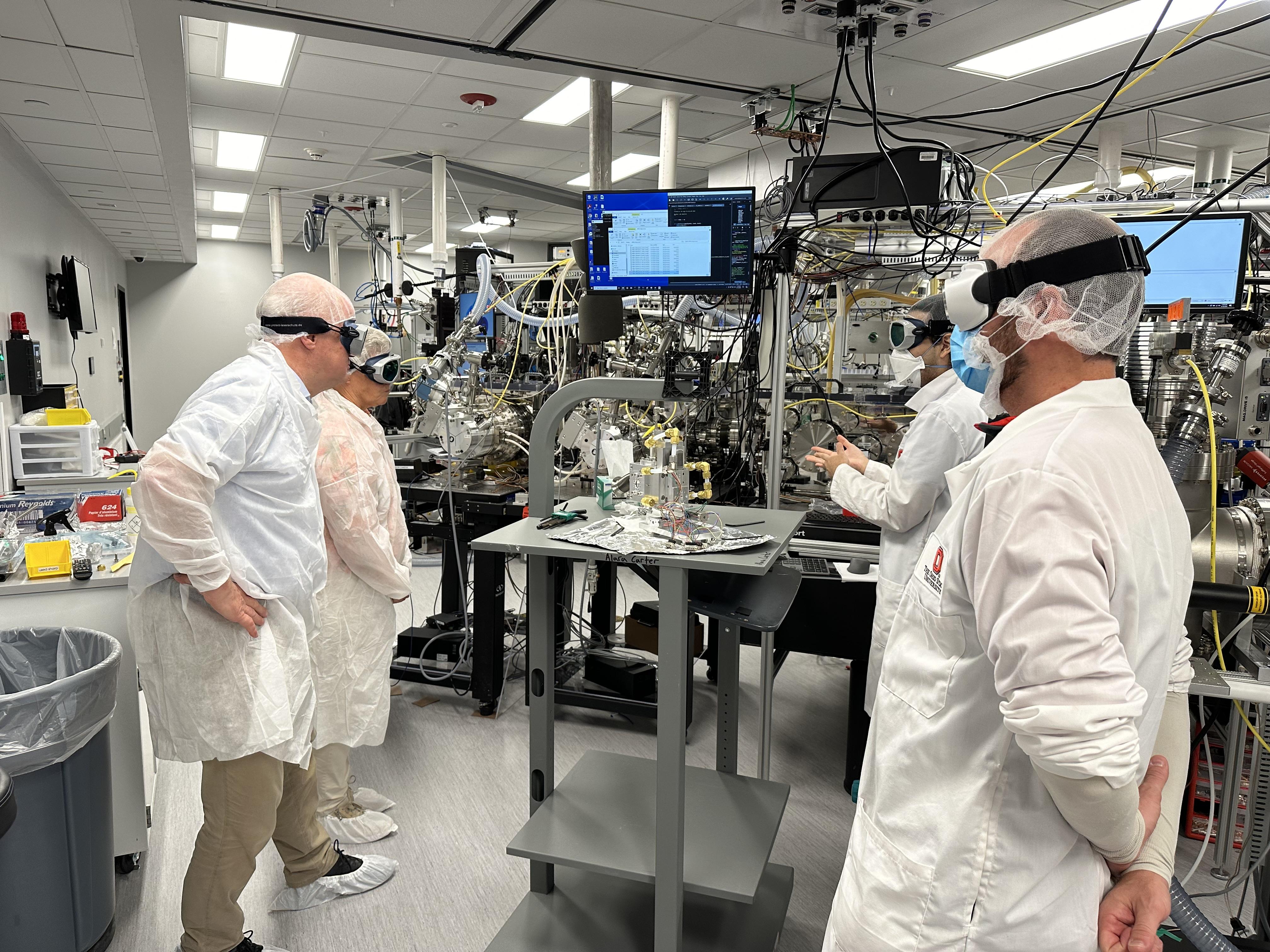 Claes-Göran Wahlström (Lund University), Anne L’Huillier (Lund University), John Beetar (NeXUS), and Tim Scarborough (NeXUS) looking at a piece of equipment in the NeXUS lab