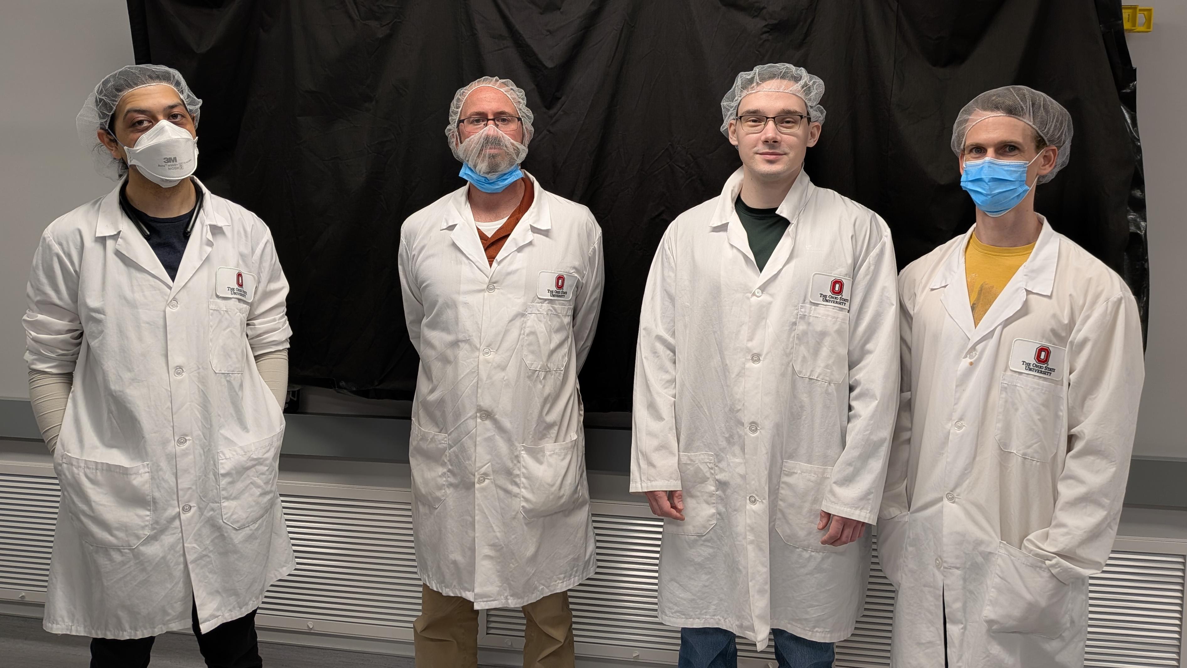 NeXUS Research Scientistis John Beetar, Tim Scarborough, Seth Shields, and Conner Dykstra standing in the NeXUS lab