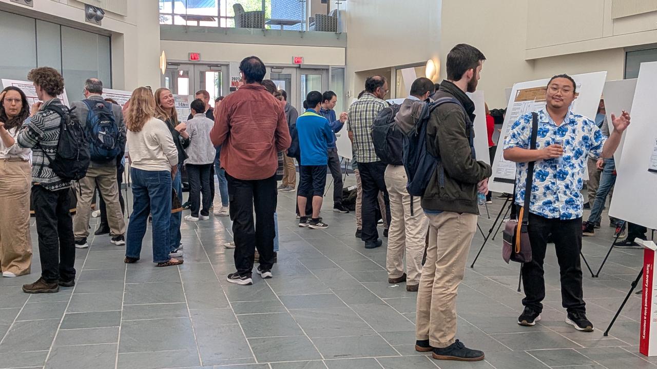 A group of workshop attendees viewing posters in a building lobby