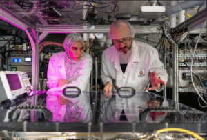 Two scientists looking into a vacuum chamber